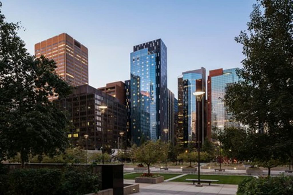 A contemporary glass hotel tower on a downtown block, photographed from across the street.
